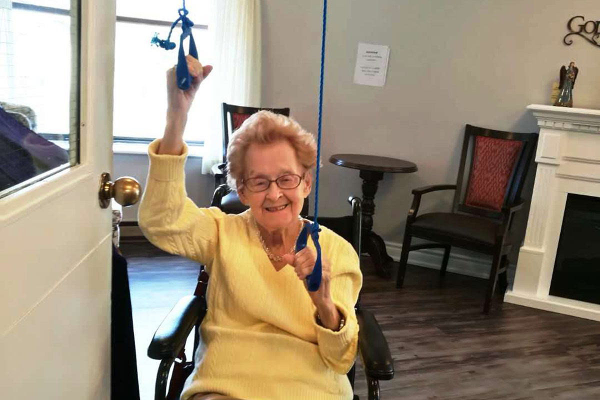 elderly female in wheelchair doing arm exercises
